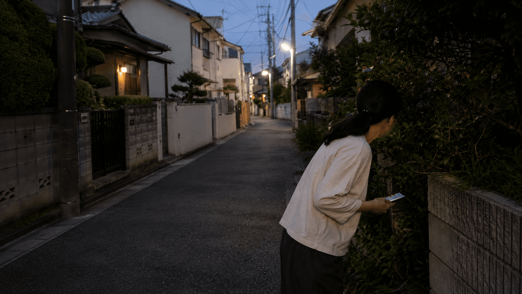 夕暮れの住宅街で愛猫を探す飼い主
